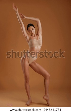 Skinny girl. Woman with slim body shape is posing against background.