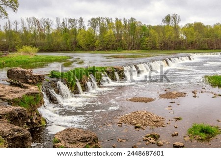 Latvia - Kuldiga - The Venta rapid, a 250-meter wide and 2-meter high natural waterfall on the Venta river, the widest in Europe, in the fall colours Royalty-Free Stock Photo #2448687601