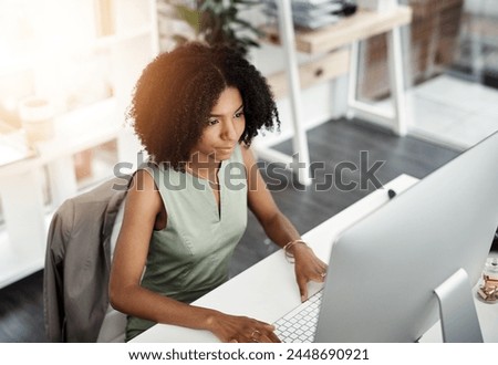 African business woman, smile and computer in office for career, online digital report and web project. Editor or young person with tech and looking at screen for typing or internet with lens flare
