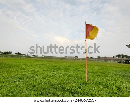corner flag on an unkempt football pitch, tall field grass.
