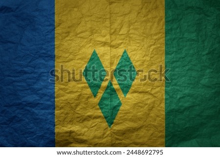colorful big national flag of saint vincent and the grenadines on a grunge old paper texture background