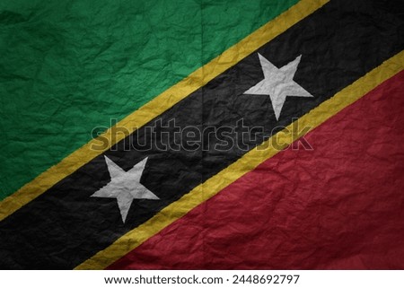 colorful big national flag of saint kitts and nevis on a grunge old paper texture background
