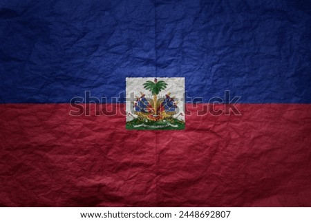 colorful big national flag of haiti on a grunge old paper texture background