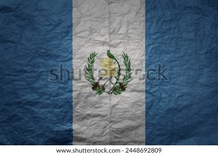 colorful big national flag of guatemala on a grunge old paper texture background