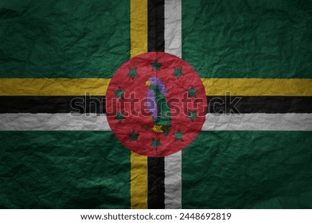 colorful big national flag of dominica on a grunge old paper texture background