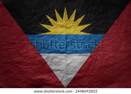 colorful big national flag of antigua and barbuda on a grunge old paper texture background