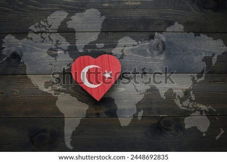 wooden heart with national flag of turkey near world map on the wooden background. concept