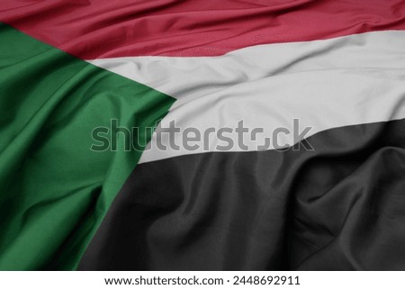 waving colorful national flag of sudan. macro shot