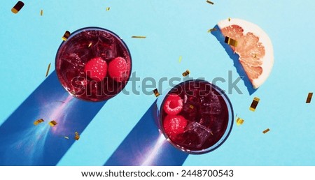 Image of confetti falling and cocktails on blue background. Party, drink, entertainment and celebration concept digitally generated image.