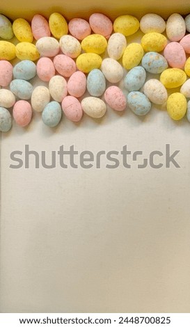 many small easter eggs on a pastel background , copy space