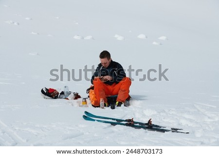 A Skier Takes a Well-Deserved Break to Enjoy the View Royalty-Free Stock Photo #2448703173