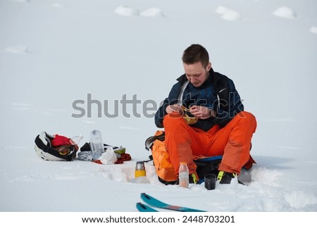 A Skier Takes a Well-Deserved Break to Enjoy the View Royalty-Free Stock Photo #2448703201