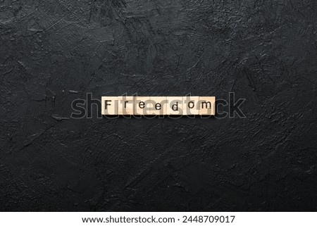 Freedom word written on wood block. Freedom text on cement table for your desing, Top view concept.
