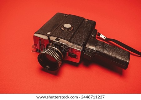 vintage portable movie camera on a red background. retro, 70s, 80s