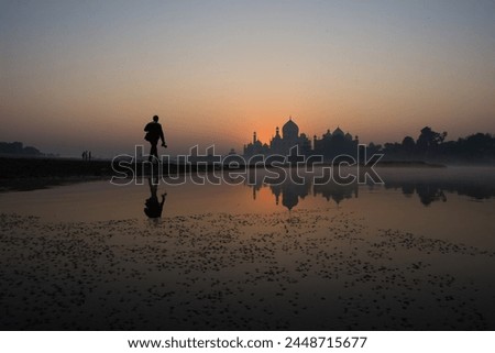
At dusk, Taj Mahal's silhouette graces the river, a serene blend of history and nature, mesmerizing under the evening sky. Royalty-Free Stock Photo #2448715677