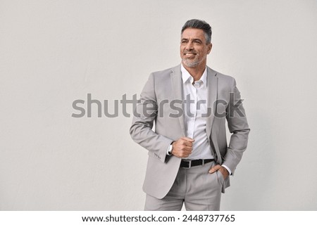 Happy middle aged business man executive investor leader thinking of future success, mature rich businessman manager lawyer wearing suit standing isolated on white background looking away. Copy space. Royalty-Free Stock Photo #2448737765