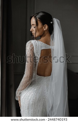 The bride is stunning in a white lace dress with intricate sleeves. Her long veil adds romance and ethereal beauty, embodying elegance and charm on this special day.