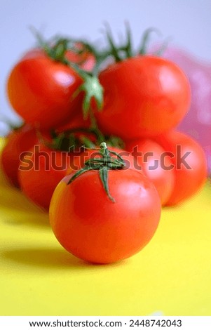 Tomatoes look very organic on the yellow background.