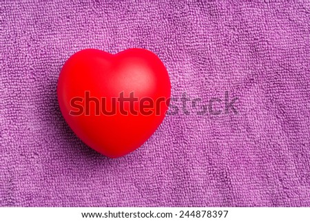 Close up red color heart on purple cloth background
