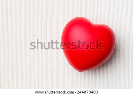 Close up red color heart on white cloth background