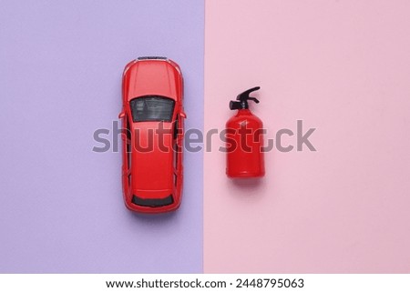 Toy extinguisher and car on a pastel background. Top view