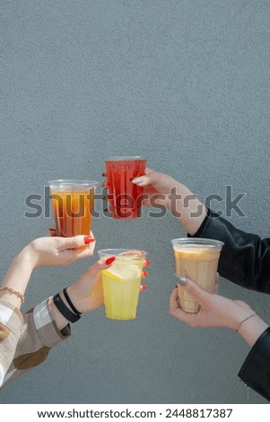 Takeaway glasses of summer drinks with ice in woman's hands. Copy space.