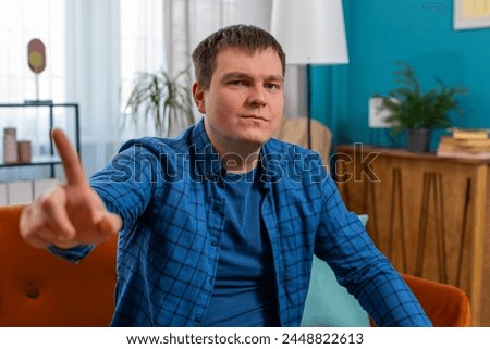 Displeased upset man reacting to unpleasant awful idea, dissatisfied with bad quality, wave hand shake finger No, dismiss idea, don't like proposal. Young Caucasian guy at home apartment room on sofa. Royalty-Free Stock Photo #2448822613