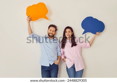 Young happy couple, paper speech balloons above, man, woman pair happy communication, dialog. People interact, information, express feeling, good conversation, discourse, chatting in close relations Royalty-Free Stock Photo #2448829305