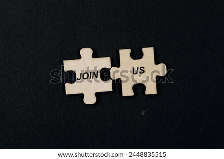 Interlocking jigsaw puzzle pieces forming the phrase JOIN US