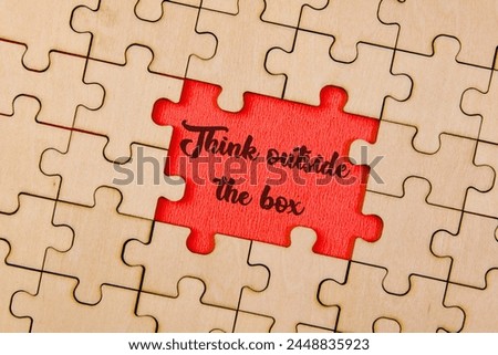 Interconnected jigsaw puzzle pieces coming together to create the phrase 'Think Outside the Box'