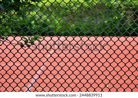 tennis court behind chainlink fence Royalty-Free Stock Photo #2448839911
