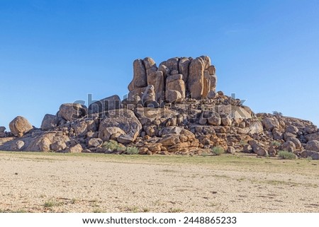 Picture of a rugged rock formation in the savannah in the south of Namibia near Fish River Canyon under a blue sky during the day