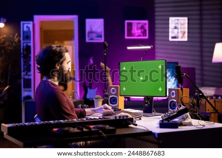 Musical engineer learning to edit and produce audio recordings by watching post production online lessons with greenscreen. Musician mixing and mastering songs, acoustical engineering.