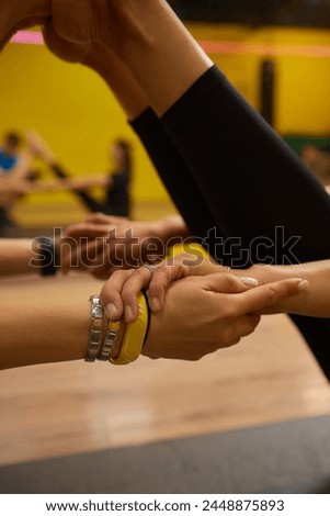 A woman is extending her legs at the gym, displaying signs of flexibility and strength. Her body movements reflect grace and control Royalty-Free Stock Photo #2448875893