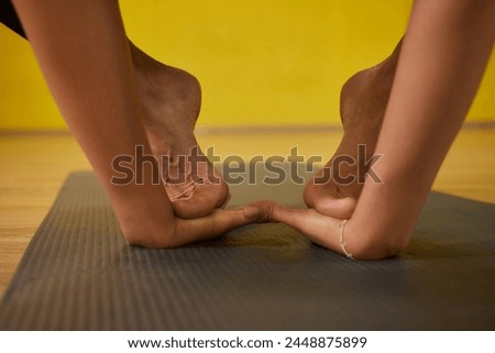 A woman is extending her legs at the gym, displaying signs of flexibility and strength. Her body movements reflect grace and control Royalty-Free Stock Photo #2448875899