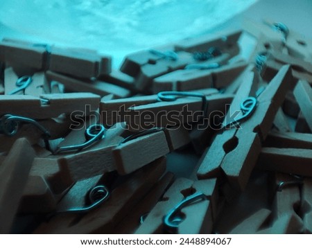 Small wooden clothespins. Macro photo of clothespins with color backlight Royalty-Free Stock Photo #2448894067