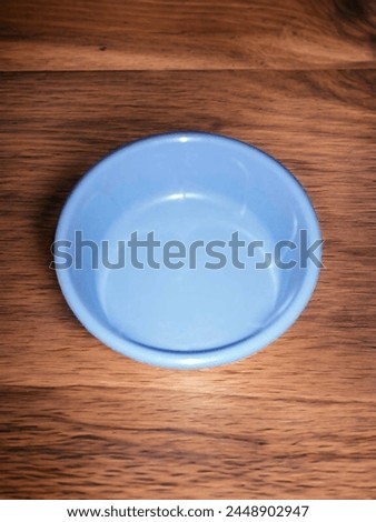 A wide blue plastic basin on the wooden floor - a basin and a large wide bowl used for washing clothes Royalty-Free Stock Photo #2448902947