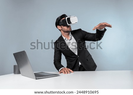 Professional project manager looking by using VR goggle while sitting at laptop. Skilled business man wearing visual reality headset while connecting metaverse or visual world. Innovation. Deviation.