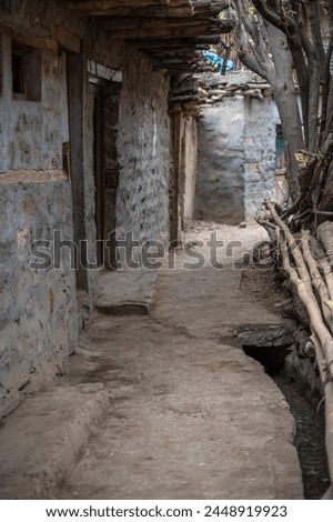 View of village mud path in Turtuk,Ladakh. Street with white soil and stone build houses. Dry logs lying at one corner. Traditional architecture,Turtuk,Ladakh , India countryside.