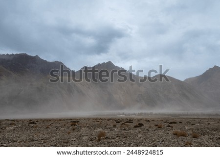 Sand storm with Himalayan mountain and dramatic clouds in the background at Sand Dunes in Hunder,Nubra Valley, Diskit, Ladakh Royalty-Free Stock Photo #2448924815