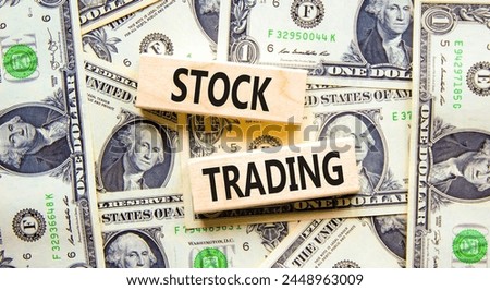 Stock trading symbol. Concept words Stock trading on beautiful wooden blocks. Dollar bills. Beautiful background from dollar bills. Business stock trading concept. Copy space.