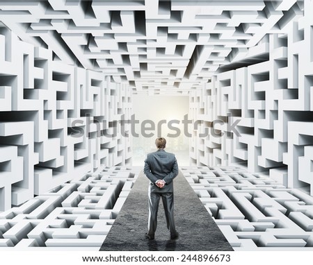 Businessman standing surrounded by labyrinth Royalty-Free Stock Photo #244896673
