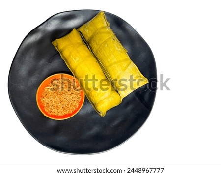 Burasa or Buras is an Indonesian rice dumpling from South Sulawesi, cooked with coconut milk packed inside a banana leaf pouch Royalty-Free Stock Photo #2448967777