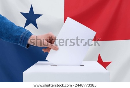 Elections, Panama. A hand throws a ballot into the ballot box. The flag of Panama on the background. The concept of voting. Royalty-Free Stock Photo #2448973385