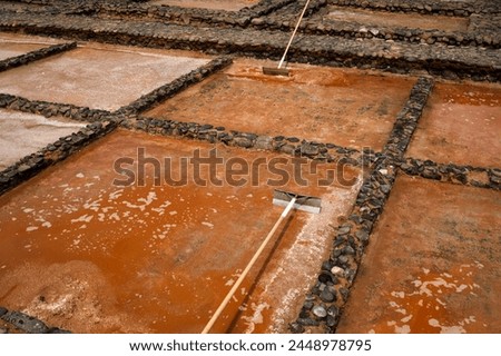 A picture of a dirty, muddy area with a broom and a mop. Scene i