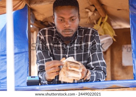 young african point of sale machine attendant standing in a boot