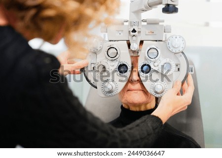 Oculist adjusting phoropter to patient. Ophthalmology concept.