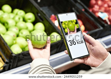 Checking calories on a apple fruit in store with smartphone