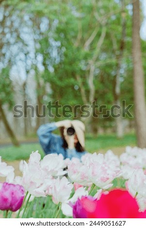 
A woman taking pictures of beautiful tulips blooming in a forest park