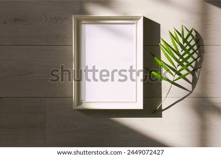 Enhance your space with this captivating image featuring green leafed plant beside a sleek white photo frame. Perfect for adding natural elegance to your decor.